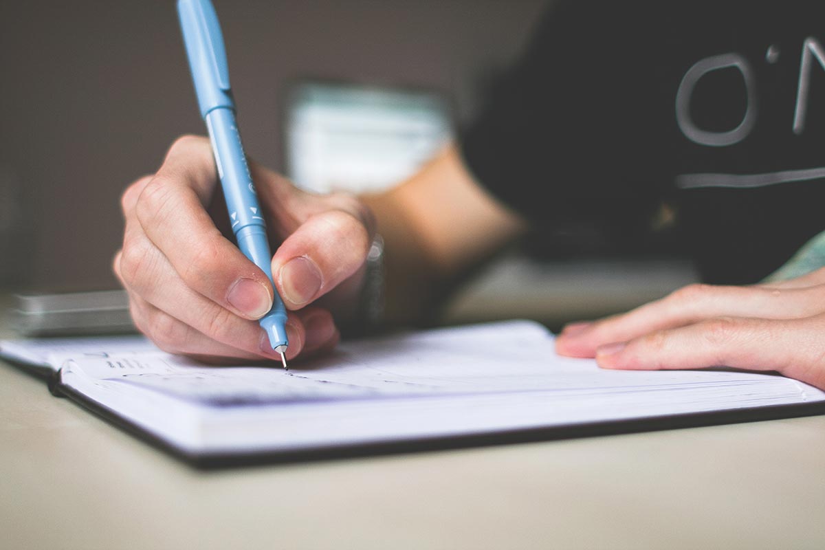 person writing in journal